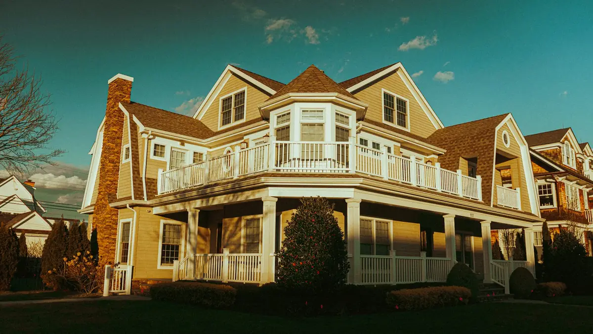 A large shingled house with a wraparound porch in golden evening light - Leak Detection in Cape Girardeau